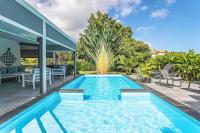 a swimming pool in the backyard of a house at Villa de 3 chambres avec piscine privee jacuzzi et jardin clos a Baie Mahault in Baie-Mahault