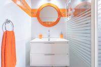 a bathroom with a white sink and an orange mirror at Villa de 3 chambres avec piscine privee jacuzzi et jardin clos a Baie Mahault in Baie-Mahault