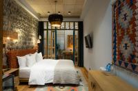 a bedroom with a white bed and a chandelier at Khedi Hotel Tbilisi in Tbilisi City