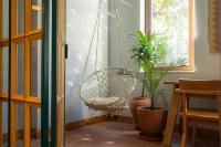 a swinging chair in a room with plants at Khedi Hotel Tbilisi in Tbilisi City