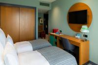 a hotel room with a bed and a desk with a television at Khedi Hotel Tbilisi in Tbilisi City