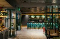a bar with green bar stools in a room at Khedi Hotel Tbilisi in Tbilisi City