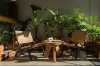 two chairs and a table in a room with plants at Khedi Hotel Tbilisi in Tbilisi City