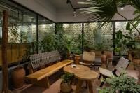 a restaurant with a bench and tables and plants at Khedi Hotel Tbilisi in Tbilisi City