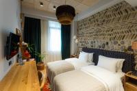 a bedroom with two beds and a wooden table at Khedi Hotel Tbilisi in Tbilisi City