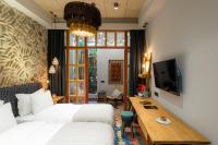 a bedroom with a bed and a desk and a tv at Khedi Hotel Tbilisi in Tbilisi City