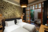 a bedroom with two beds and a wall of windows at Khedi Hotel Tbilisi in Tbilisi City