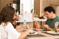 ピラトゥバにあるEstação Termas Hotelのテーブルに座って食事を楽しむ人々のグループ