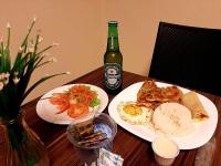 einen Tisch mit zwei Teller Essen und einer Flasche Bier in der Unterkunft Cast Comfort Hotel in Paranaíba