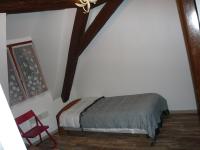 a bedroom with a bed and a red chair at La cour des meuniers - le Froment et l&#39;Epeautre in Kaysersberg