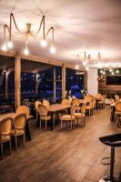 a dining room with tables and chairs and lights at Green Resort Suncuius in Şuncuiuş