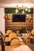 a restaurant with tables and chairs and a flat screen tv at Green Resort Suncuius in Şuncuiuş