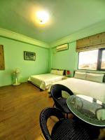 a room with two beds and a table and chairs at Dreamily Fish B&amp;B in Magong