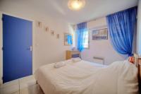 a bedroom with a large bed with blue curtains at Very pleasant 2 rooms garage near the beaches in Cannes
