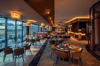a restaurant with tables and chairs and windows at Hyatt Regency Dusseldorf in Düsseldorf