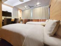 a hotel room with two beds and a desk with chairs at CHECK inn Express Taichung Fengchia in Taichung