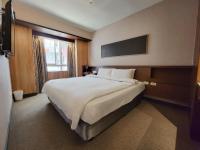 a bedroom with a large white bed with a window at CHECK inn Express Taichung Fengchia in Taichung