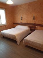 two beds in a room with wooden walls at La Cremaillere in Miremont