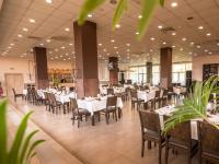 Un comedor con mesas y sillas blancas. en Парк хотел Кюстендил, en Kyustendil