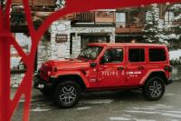 a red jeep parked in front of a building at Hôtel La Sivolière in Courchevel