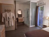 una habitación de hotel con una bata colgada en una puerta en Le Mas Blanc, en Carcassonne