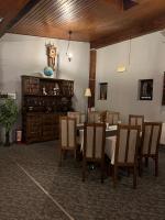 een eetkamer met een tafel, stoelen en een klok bij PENSIUNEA UNO in Timişoara