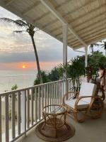 a porch with a chair and a table on the beach at Lihinya Beach Villa Ahangama in Ahangama