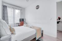 a white bedroom with a bed and a chair at Cozy - Free Parking - 15mn from Paris Montparnasse in Clamart