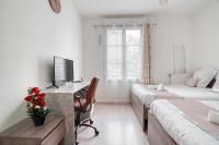 a bedroom with two beds and a desk with a computer at Cozy - Free Parking - 15mn from Paris Montparnasse in Clamart