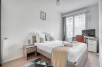 a white bedroom with a bed and a tv at Cozy - Free Parking - 15mn from Paris Montparnasse in Clamart