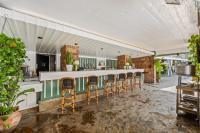 a kitchen with a long bar with chairs at The Hollywood Roosevelt in Los Angeles
