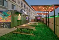 um grupo de mesas de piquenique em frente a um edifício em Wingate by Wyndham - DFW North em Irving