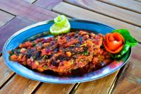 a blue plate of food on a wooden table at ROYAL ACACIA HOTEL ISIOLO in Tarbaj