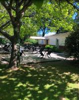un groupe de tables de pique-nique et un arbre dans une cour dans l'établissement Les cabanes de l'île aux oiseaux Guern, à Guern