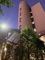 Un edificio alto de ladrillo con un árbol delante. en Inuyama City Hotel, en Inuyama