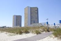 two tall buildings on the beach with a boardwalk at IFA Fehmarn Hotel &amp; Ferien-Centrum in Burg auf Fehmarn