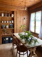 a dining room with a table with flowers on it at Berghotel Gasterntal in Kandersteg