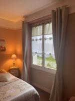 a bedroom with a bed and a window with curtains at Le Moulin du Modon in Couffy