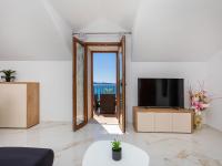 a living room with a tv and a mirror at Villa Ana Apartments in Mlini