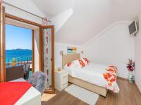 a bedroom with a bed and a balcony with the ocean at Villa Ana Apartments in Mlini