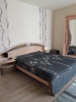 ein Schlafzimmer mit einem großen Bett und einem Spiegel in der Unterkunft Bokor Vendégház in Szentes