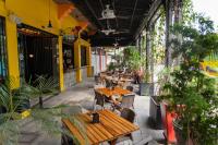 Un patio al aire libre con mesas, sillas y plantas. en Hotel El Meson, en La Dorada