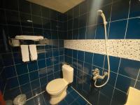 a blue tiled bathroom with a toilet and a shower at Jiuning Business Hotel in Tainan