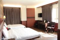 a hotel room with two beds and a desk and a television at Lu Fang View in Donggang