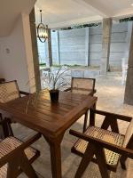 una mesa de madera con sillas y una maceta en un patio en Ami Mirissa, en Mirissa