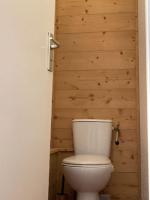 a white toilet in a bathroom with a wooden wall at Appartement Alpe Huez 8 personnes centre station in LʼHuez