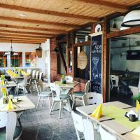 Un restaurante con mesas y sillas y una pizarra. en Pension Pfefferstübchen, en Brotterode