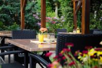 una mesa de madera con flores en el patio en Pension Pfefferstübchen, en Brotterode