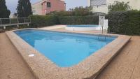 a large blue swimming pool in a yard at Vue Mer 180° Parking+Lave-Linge+Proche Plages+Piscine in Cap d&#39;Agde