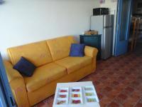 a living room with a yellow couch and a table at Vue Mer 180° Parking+Lave-Linge+Proche Plages+Piscine in Cap d&#39;Agde